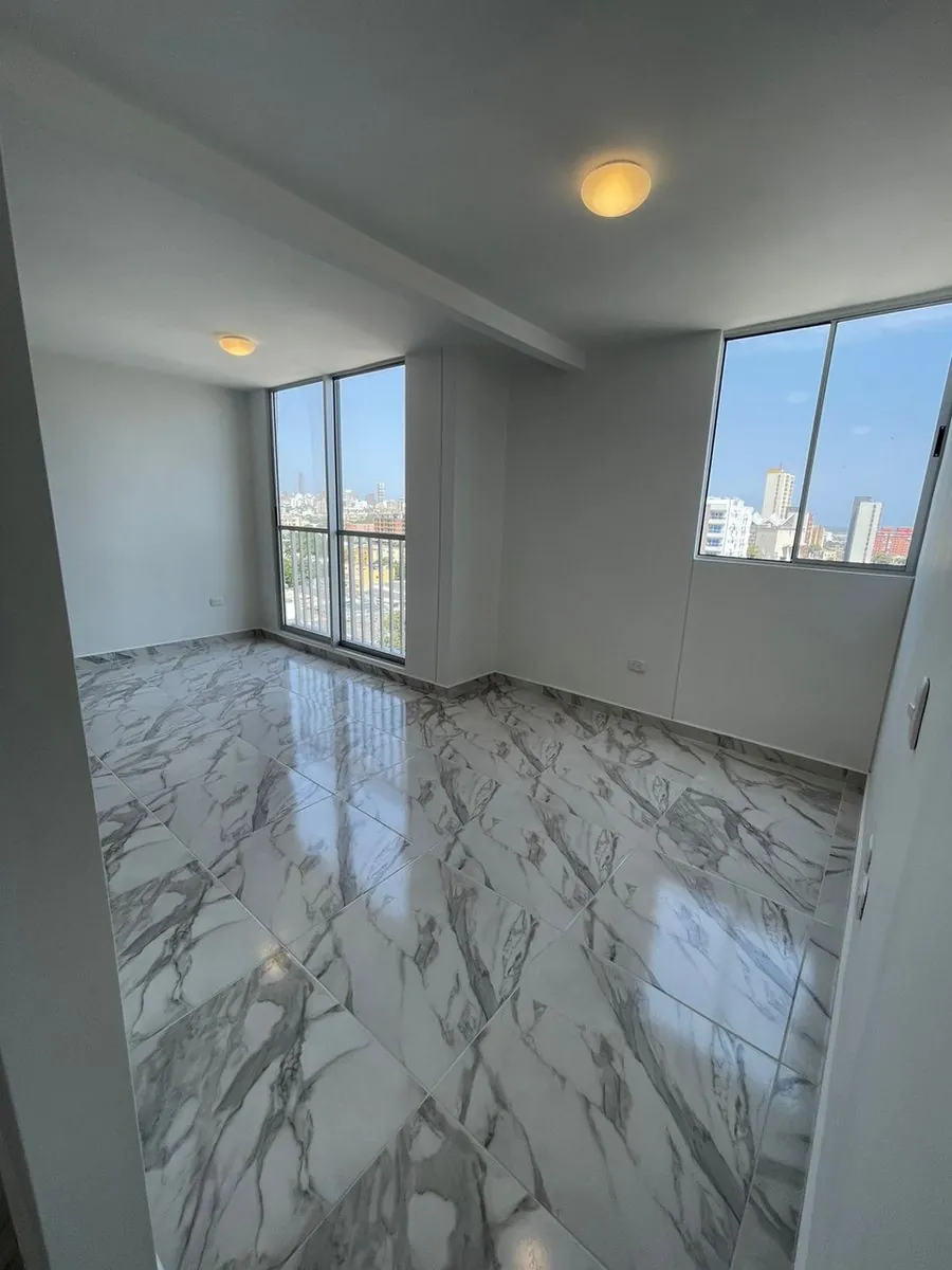Sala de apartamento remodelado con piso tipo mármol y ventanales