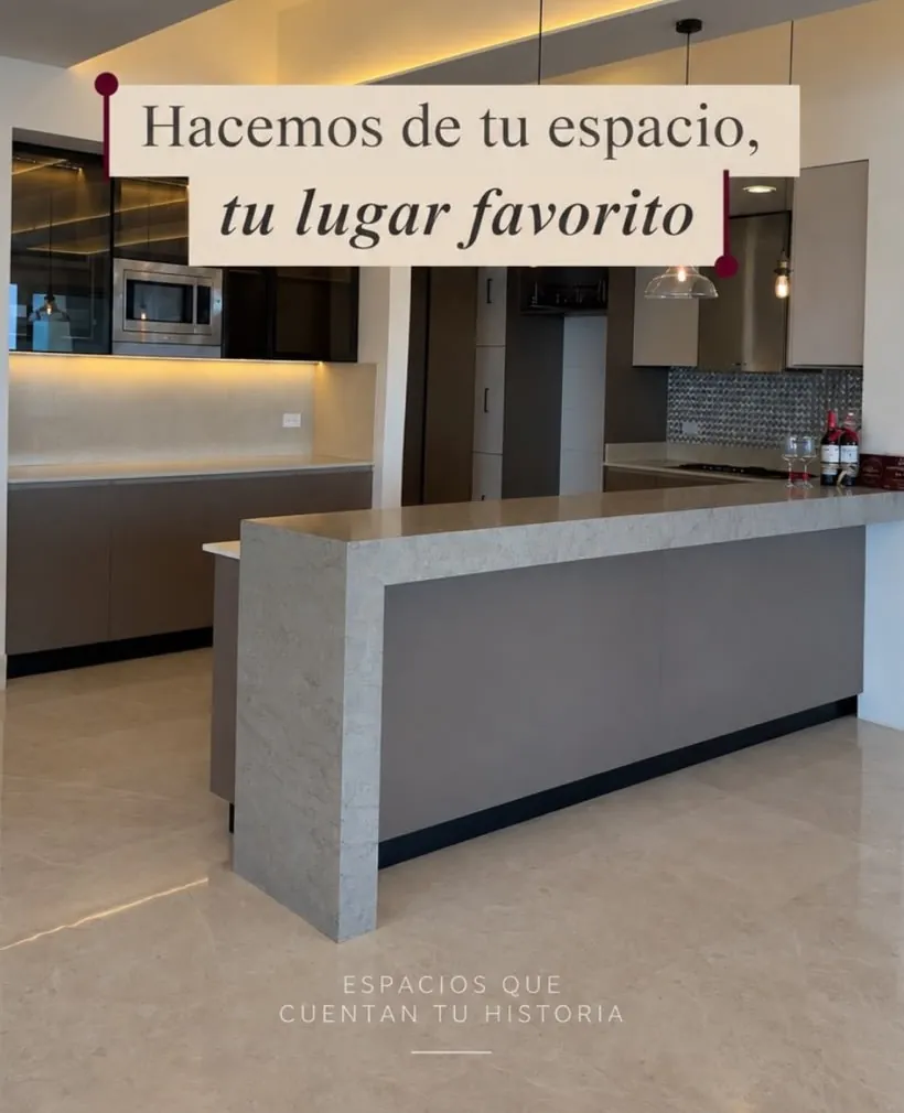 Cocina con barra en piedra e iluminación indirecta, con el lema «Hacemos de tu espacio, tu lugar favorito»