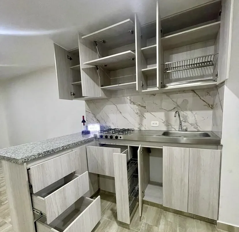 Cocina en L con cajones y gabinetes abiertos mostrando el interior