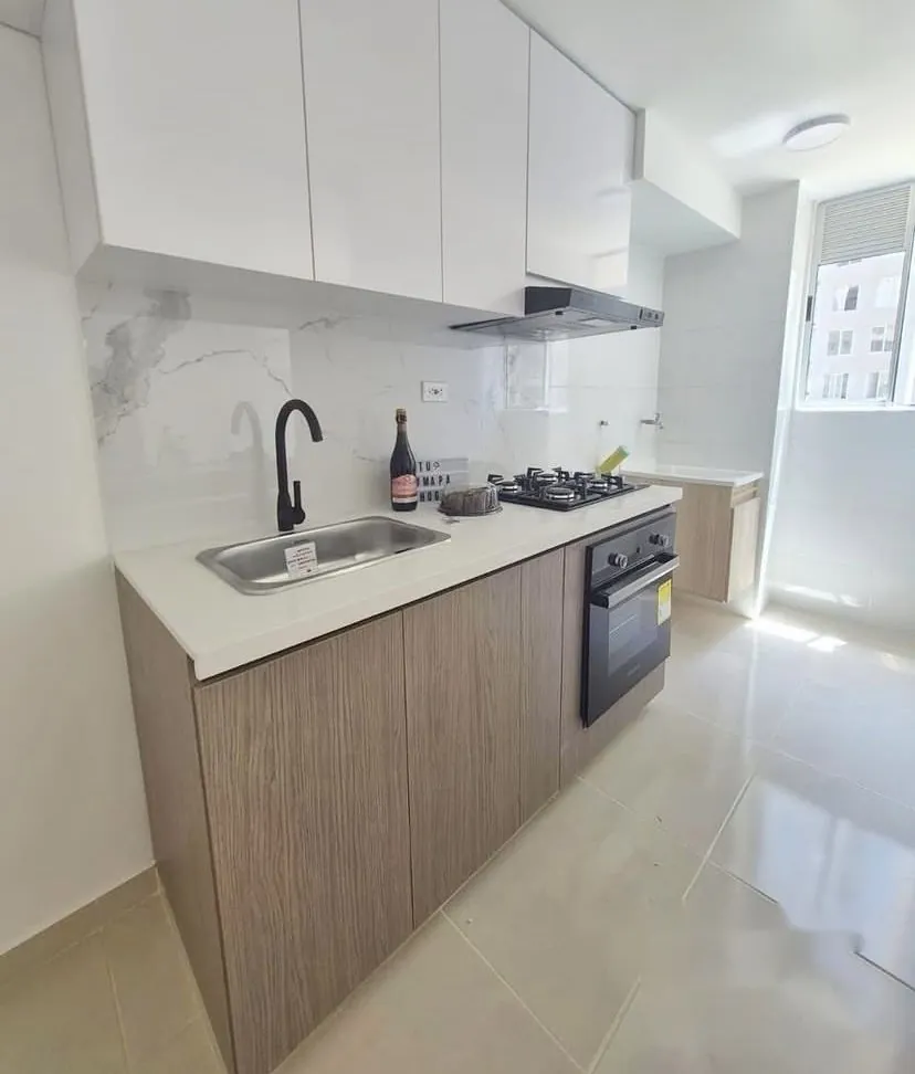Cocina con gabinetes superiores blancos y muebles bajos en madera