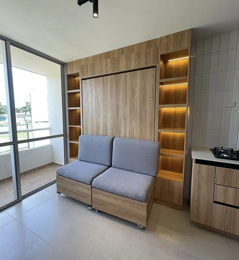 Sala con sofá modular integrado entre nichos de madera iluminados